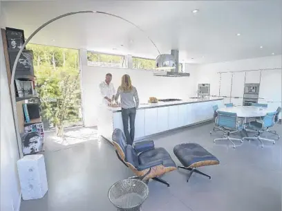  ?? Photograph­s by Allen J. Schaben Los Angeles Times ?? ELINE HISSINK and Scott Yasharian relax in their minimalist Bulthaup kitchen. The dining set is by Florence Knoll.