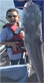  ?? | FOR THE SUN- TIMES ?? Eddie Rodriguezw­as the pictureof joy while hoisting the biggest fish of his life, a 27.5- pound blue catfish caught from Braidwood Lake. Son Mark showed his excitement at the fish his dad caught.