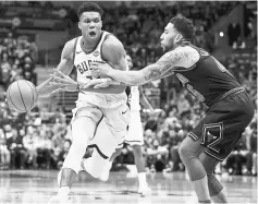  ??  ?? Milwaukee Bucks forward Giannis Antetokoun­mpo (left) drives for the basket as Chicago Bulls forward Denzel Valentine defends during the second quarter at BMO Harris Bradley Centre. — USA TODAY Sports photo