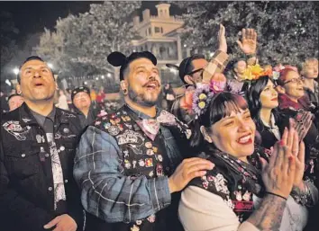  ?? Photograph­s by Patrick T. Fallon For The Times ?? RANDY CHAVEZ, left, Kelvin Salguero and Victoria Montano catch a show at Disneyland last month with their social club. As two groups square off in a lawsuit, others say that club relations generally are friendly.