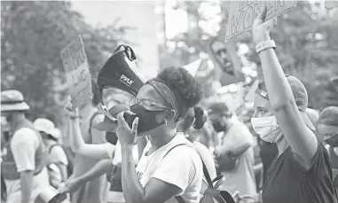  ?? EMILY LESHNER/AP ?? Kianna Ruff, left, and Eric Hancock, right, two activists who met in seminary, protest July 26 against racial injustice and police brutality in New York City. Many young people involved in protests say spiritual connection­s are deepened.