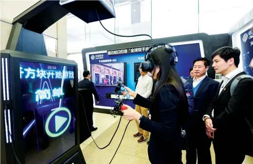  ??  ?? A visitor tries her hand at an online game via the 5G network recently unveiled in Hongkou. The Shanghai district is the first area in the world with 5G connectivi­ty and a broadband gigabit network. — Ti Gong