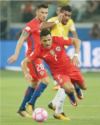  ?? — Reuters ?? Alexis Sanchez of Chile and Paulinho of Brazil in action.