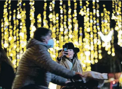  ?? ALEJANDRO GARCIA / EFE ?? Una mujer se fotografía con las luces del paseo de Gràcia de Barcelona de fondo