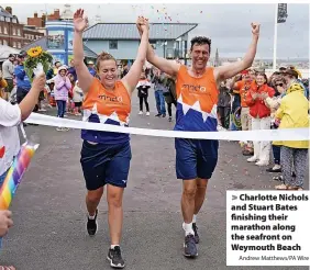  ?? Andrew Matthews/PA Wire ?? Charlotte Nichols and Stuart Bates finishing their marathon along the seafront on Weymouth Beach