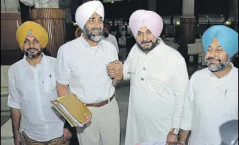  ?? KESHAV SINGH/HT ?? Finance minister Manpreet Singh Badal, who tabled two white papers in the House, with his cabinet colleague Navjot Singh Sidhu in Chandigarh on Monday.