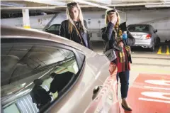  ?? Gabrielle Lurie / The Chronicle ?? Julia Wilkinson (left) and her mother, Mary Wilkinson, of Charlotte, N.C., listen as San Francisco police officers discuss the investigat­ion into the theft of items from their rental car.