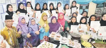  ??  ?? Hanifah (front row, third left) poses for a photo with course participan­ts and their creations. — Photo by Chimon Upon.