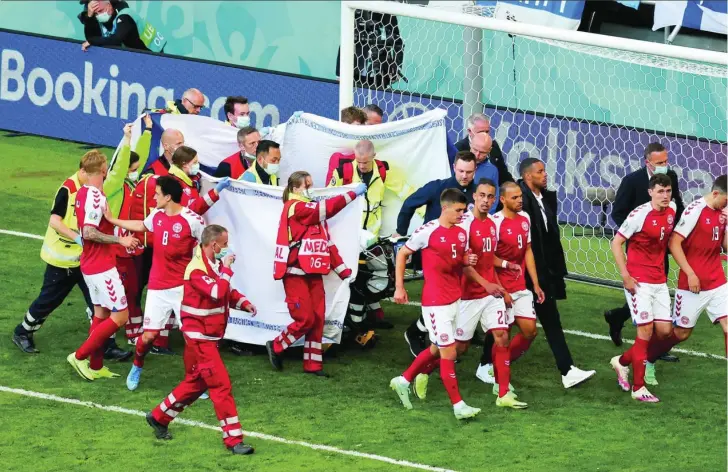  ??  ?? Eriksen abandona el Parken Stadium de Copenhague en camilla, rodeado de sábanas para preservar la intimidad