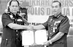  ??  ?? Adzhar Othman (right), handing over the pledge to Labuan MACC director Abdulamin Abdillah. - Bernama photo