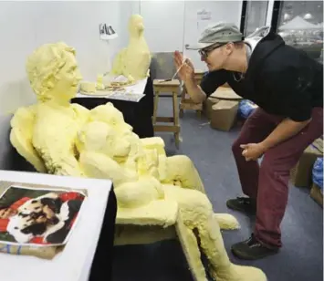  ?? RICHARD LAUTENS PHOTOS/TORONTO STAR ?? Sculptor Sean Masonic works on a buttery likeness of Prime Minister Justin Trudeau holding two Panda cubs.