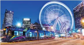  ??  ?? The Atlanta Streetcar glides past the SkyView Atlanta ferris wheel. There are great city views from the wheel at night.