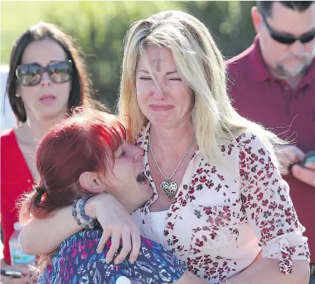  ?? — THE ASSOCIATED PRESS ?? Parents wait outside for news after reports of a shooting at Marjory Stoneman Douglas High School in Parkland, Fla., on Wednesday. At least 17 people were reported to be killed.