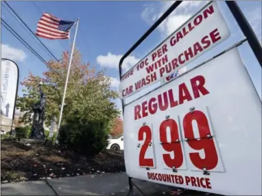  ??  ?? An American flag flies at a gas station advertisin­g a discounted price for gas at $2.99 per gallon, with the purchase of a car wash, in Lynnwood, Wash. The U.S. is on track for the lowest annual average gas price since 2010— and the 2015 average is...