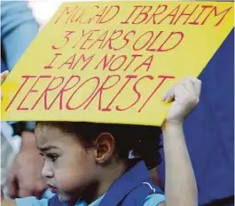  ??  ?? A participan­t in the Solidarity for Peace rally holding a sign in Kuala Lumpur yesterday.