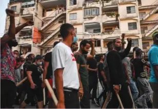  ??  ?? Grupos afines al gobierno de Díaz-Canel caminan por las calles de La Habana.