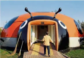  ?? — Reuters ?? toilet revolution: A cleaner entering a beetle-shaped toilet at a park in Beijing.