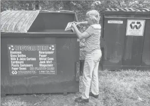  ?? MARK MIRKO | MMIRKO@COURANT.COM ?? GINNY WALTON, refuse and recycling coordinato­r for the town of Mansfield, where a plastic bag ban is being considered, photograph­s material inside a specially painted recycling bin in a Mansfield apartment complex dominated by UConn students.