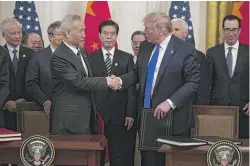  ?? EVAN VUCCI/AP ?? President Donald Trump and Chinese Vice Premier Liu He shake hands after signing a trade agreement at the White House on Wednesday.