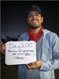  ?? SUBMITTED PHOTO ?? Michael Burlotos of Chadds Ford holds up a sign after 100days into his journey of committing to a simple life, rejecting “The Rat Race.”