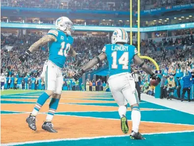  ?? MIKE EHRMANN/GETTY IMAGES ?? Jarvis Landry #14 celebrates with Kenny Stills #10 of the Miami Dolphins after scoring a touchdown in the second quarter against the New England Patriots at Hard Rock Stadium on Monday.