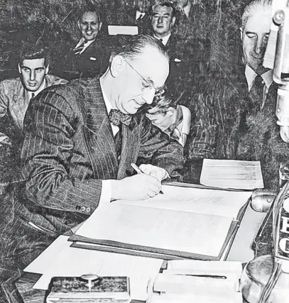  ?? COURTESY OF THE ROOMS PROVINCIAL ARCHIVES ?? Joseph R. Smallwood signs the Terms of Union between Canada and Newfoundla­nd and Labrador in Ottawa on Dec. 11, 1948.