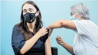  ?? Photo / Michael Craig ?? Prime Minster Jacinda Ardern receives her booster shot yesterday at a vaccinatio­n centre in St Johns, Auckland.