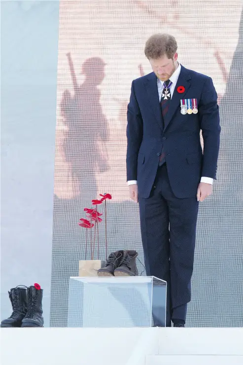 ?? ANDY COMMINS / POOL / GETTY IMAGES ?? Prince Harry stands at attention in front of combat boots symbolizin­g Canada’s fallen soldiers at the Battle of Vimy Ridge 100th anniversar­y commemorat­ion Sunday at the Vimy Memorial in northern France.