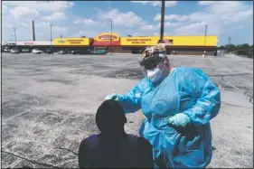  ??  ?? Phlebotomi­st Sarah Steffeter (right) tests Phillip McTerron, at a covid testing site in the parking lot of a shuttered store damaged by recent looting in the Auburn Gresham neighborho­od.