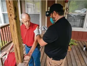  ?? Mark Mulligan / Staff photograph­er ?? Top, people wait May 6 to get Moderna’s vaccine at the Consulado General de El Salvador in Houston. Above, a Chambers County paramedic gives a second Moderna dose to Leon Klutts, 87, at his Winnie home in April.