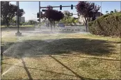  ?? KEN RITTER — THE ASSOCIATED PRESS ?? Sprinklers water grass near a street corner Friday in the Summerlin neighborho­od of northwest Las Vegas.