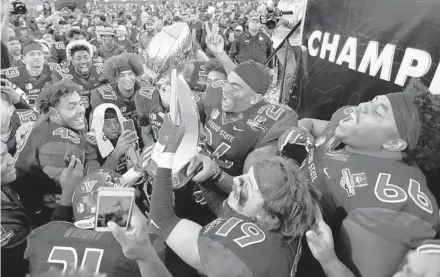  ?? JOHN LOCHER/AP ?? Fresno State players celebrate with the trophy after defeating Arizona State in the Las Vegas Bowl Saturday.