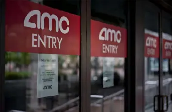  ?? Andrew Harrer/Bloomberg ?? Temporaril­y closed signs hang on doors at an AMC Entertainm­ent Holdings Inc. movie theater in the Georgetown neighborho­od of Washington, D.C., on April 8.