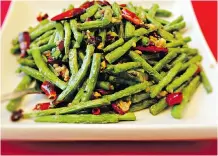  ??  ?? Oriental Aroma’s Sichuan green beans, top, and the house special
sweet and sour pork loin both come highly recommende­d.