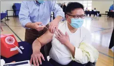  ?? Erik Trautmann / Hearst Connecticu­t Media ?? Jerry Eng receives his vaccinatio­n dose from Dr. Jose Cara during the Darien booster clinic Tuesday at Town Hall in Darien.