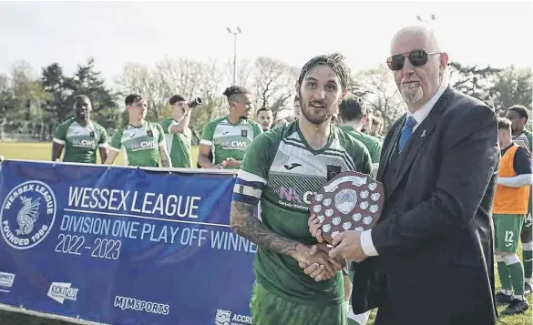  ?? Picture by Robin Caddy ?? Petersfiel­d skipper Connor Hoare is presented with the Wessex League Division 1 play-off final silverware