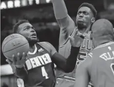  ?? Jonathan Daniel, Getty Images ?? Paul Millsap, trying to score Wednesday night against the Bulls at the United Center in Chicago, contribute­d 22 points, eight rebounds and five steals to the Nuggets’ 135-102 victory. Millsap made eight of his nine shots from the field.