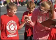  ??  ?? French Creek Elementary School teacher Tara Torres checks fourth grader, Hunter Young’s pedometer.