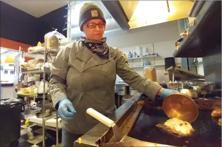  ?? ZACHARY SRNIS — THE MORNING JOURNAL ?? Mary Fields, owner of Broadway Mary’s and Brew & Stew, cooks the mushroom Swiss burger at Broadway Mary’s.