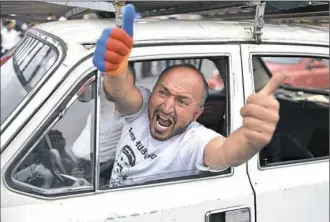  ?? Sergei Gapon/AFP/Getty Images ?? A supporter of opposition leader Nikol Pashinian gestures and shouts slogans from inside a car Tuesday in Yerevan’s central Republic Square as parliament voted to elect Mr. Pashinian prime minister.