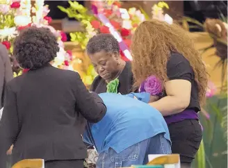  ?? MARIE DE JESUS/HOUSTON CHRONICLE ?? Three women hold a man as he becomes emotional approachin­g the casket of Jazmine Barnes during a viewing ceremony before the funeral Tuesday at the Community of Faith Church in Houston.