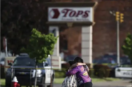  ?? JOSHUA BESSEX — THE ASSOCIATED PRESS ?? People hug outside the scene of a shooting at a supermarke­t on Saturday in Buffalo, N.Y. Police say 11of the victims are Black and two are White.