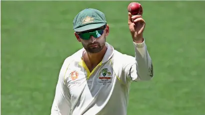  ?? Reuters ?? Australia’s Nathan Lyon shows the ball as he leaves the field on day four of the first Test against India. —