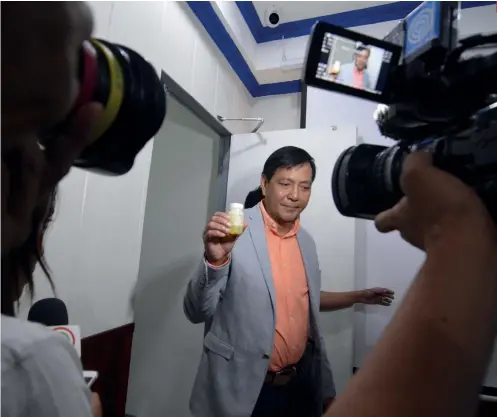  ?? SUNSTAR FOTO / AMPER CAMPAÑA ?? DRUG TEST. Former mayor Michael Rama shows reporters a plastic bottle containing a sample of his urine during a drug test at the Police Regional Office 7.