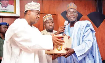  ??  ?? Governor Ibrahim Gaidam of Yobe State (left) receives a completed handwritte­n copy of the Holy Qur’an from Alhaji Lawan Abba Shettima, coordinati­ng chairman of the committee on ‘Khattul Barnawy’ project in Damaturu yesterday