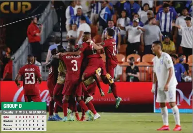  ?? (AFP) ?? Qatar players mob midfielder Abdelaziz Hatim after he scoring during the CONCACAF Gold Cup match against Honduras at the BBVA Stadium in Houston, Texas, on Tuesday. Qatar won 2-0 to top Group D.