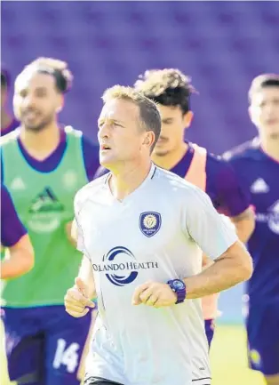  ?? JACOB LANGSTON/STAFF PHOTOGRAPH­ER ?? Orlando City coach Jason Kreis, center, leads his team through drills Tuesday. ESPN analyst Taylor Twellman says Kreis faces more pressure to help the Lions reach the playoffs this season.