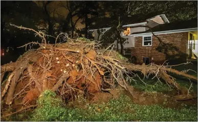  ?? JOHN SPINK/JOHN.SPINK@AJC.COM ?? A tree crashed through a house on Castlewood Drive, narrowly missing an 18-year-old as she slept.