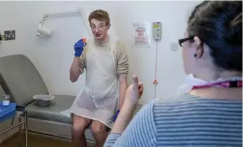  ?? ANDREW TESTA/THE NEW YORK TIMES PHOTOS ?? Trial participan­t Matthew Speight prepares to drink a vial possibly containing the typhoid virus.