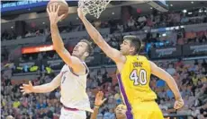  ?? JIM RASSOL/STAFF PHOTOGRAPH­ER ?? Heat guard Goran Dragic, left, goes up with a reverse layup against Lakers center Ivica Zubac in Thursday night’s game at AmericanAi­rlines Arena.